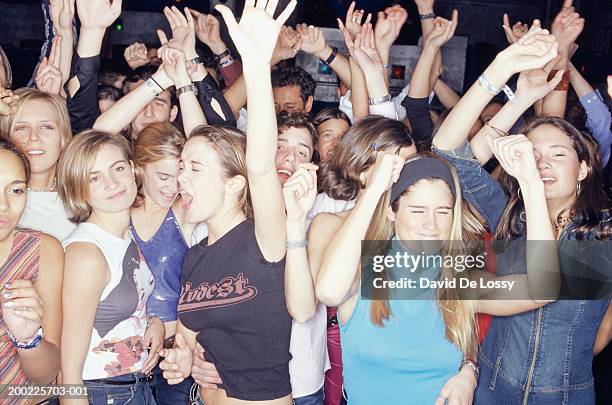 large group of teenagers dancing at club, front view - teenage girl club stock-fotos und bilder