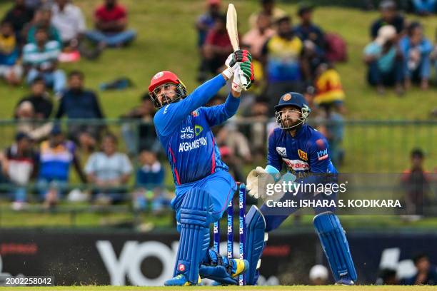 Afghanistan's Mohammad Nabi plays a shot as Sri Lanka's captain and wicketkeeper Kusal Mendis watches during the third and final one-day...