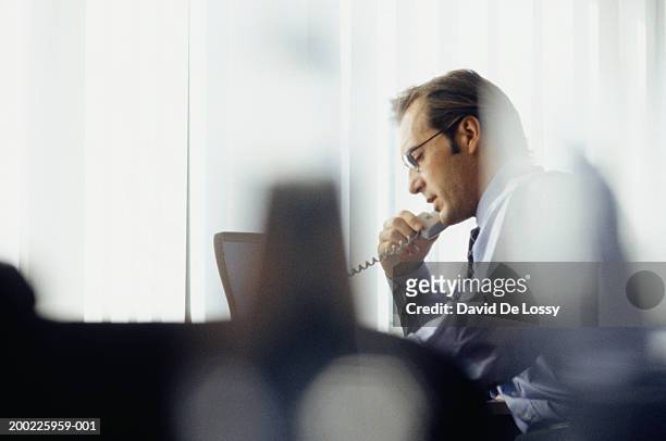 businessman using phone in office - landline phone foto e immagini stock