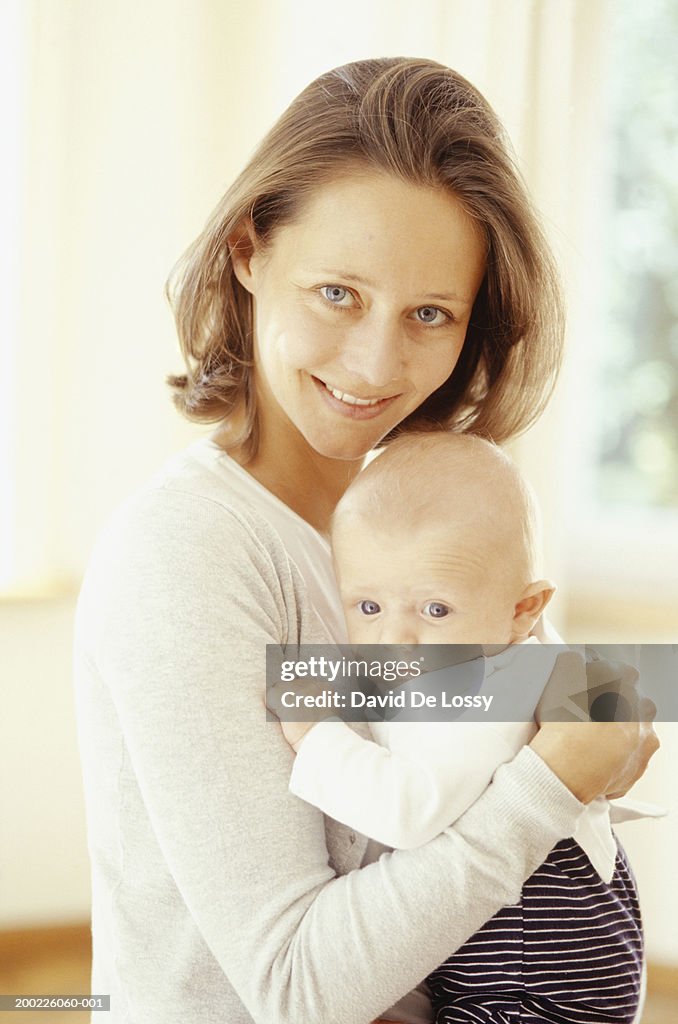 Mother holding baby (3-6 months), portrait