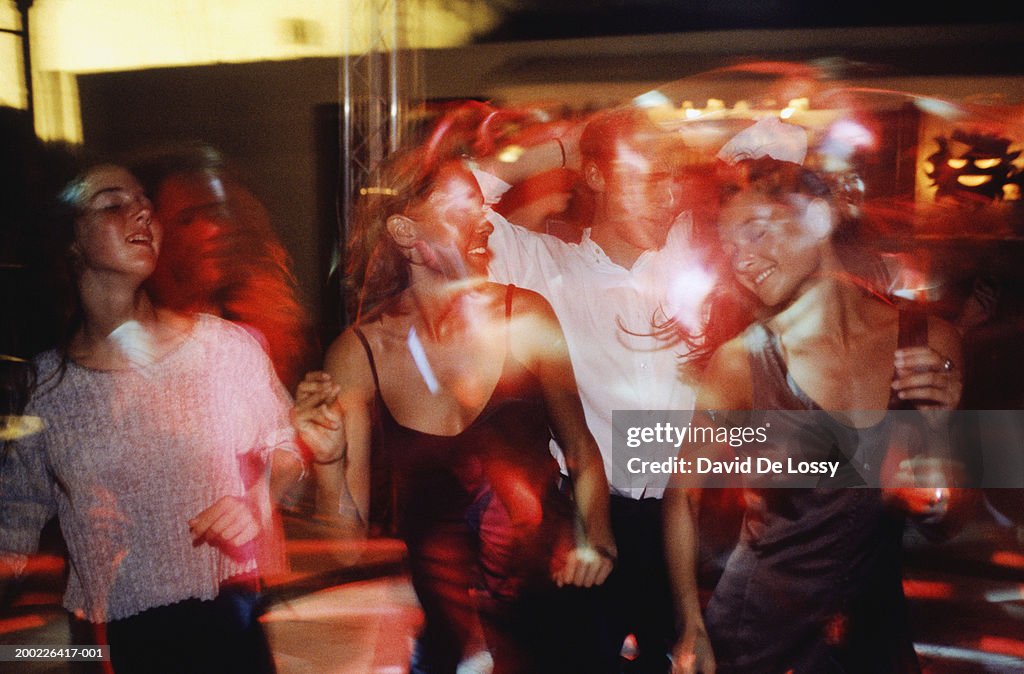 Group of young men and women dancing in bar