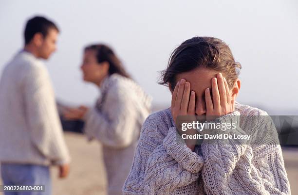 couple arguing, girl (12-13 years) covering eyes with hands, waist up - family problems bildbanksfoton och bilder