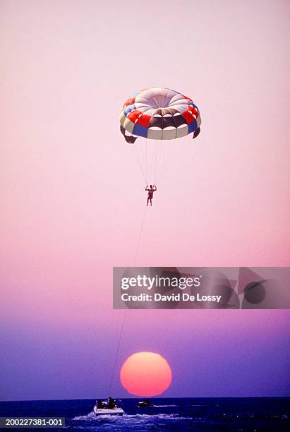 man parachuting over sea at sunset, - parasailing stock pictures, royalty-free photos & images