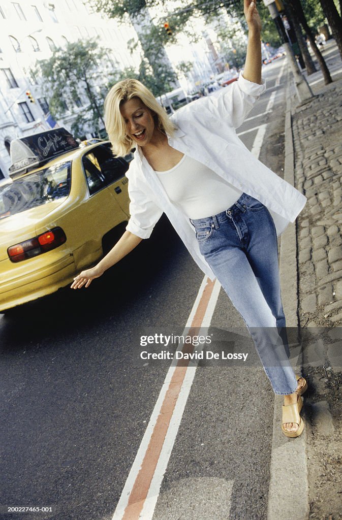 Woman balancing on curb along street