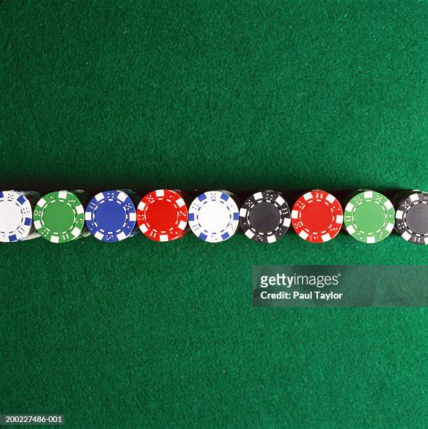 poker chips lined up on casino table - casino tokens checks or chips stock pictures, royalty-free photos & images