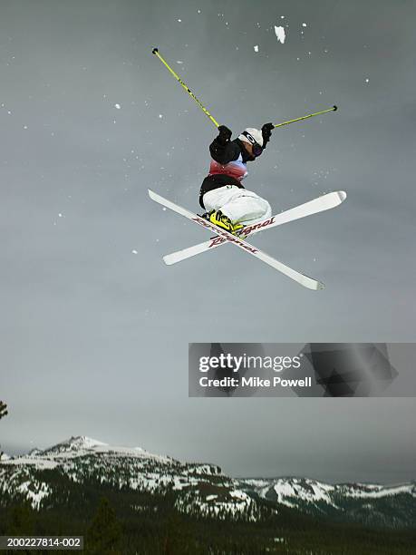 skier doing freestyle jump in air - freistil stock-fotos und bilder