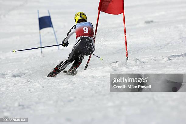 female skier in giant slalom ski race, rear view - slalom skiing fotografías e imágenes de stock