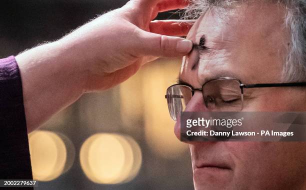 Canon Claire Renshaw makes an ash cross on the forehead of the Very Reverend John Dobson, during the imposition of the ashes during the Ash Wednesday...