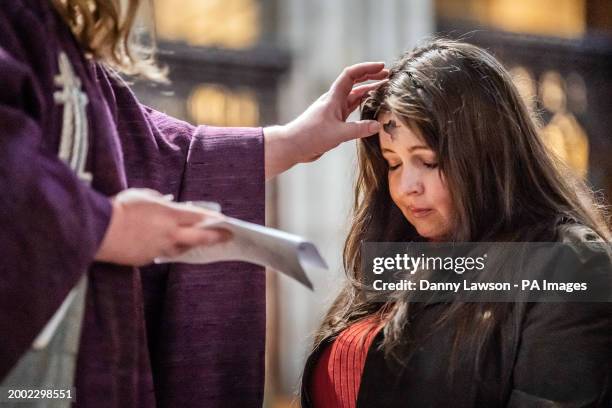 Canon Claire Renshaw makes an ash cross on the forehead of parishioner Lucy Lexington, during the imposition of the ashes during the Ash Wednesday...