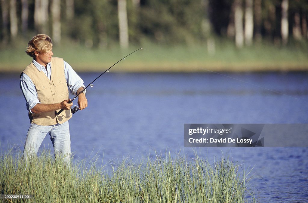 Man Casting Fishing Line By Lake High-Res Stock Photo - Getty Images