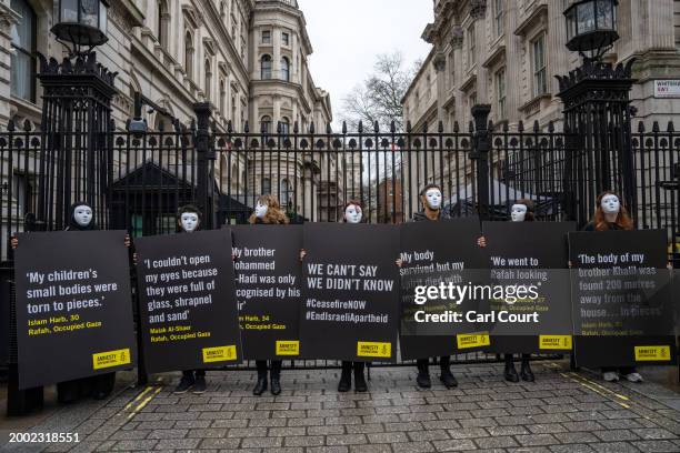 Amnesty International UK protesters hold placards outside Downing Street to raise attention to the plight of Palestinian civilians in the Gazan...