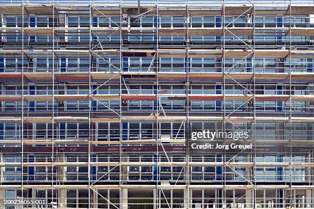 scaffolding covering exterior of office building - scaffolding stock pictures, royalty-free photos & images