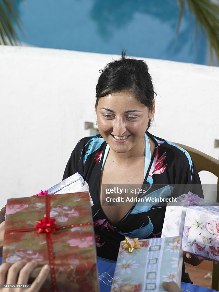 Woman being presented with gifts, smiling