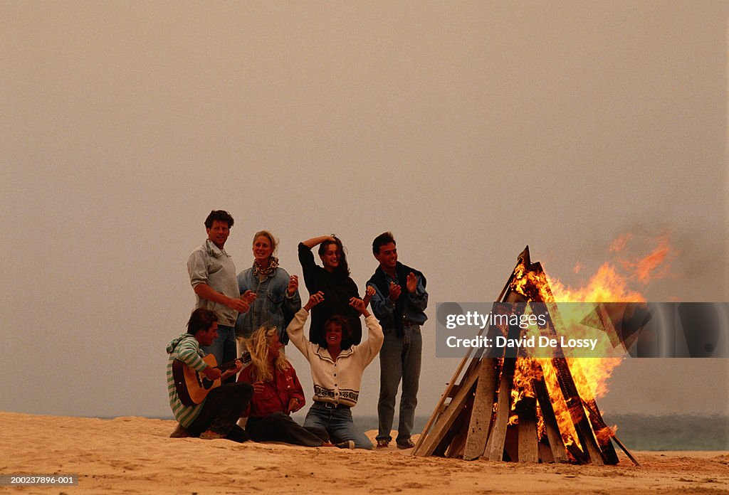 Group of people by campfire at beach