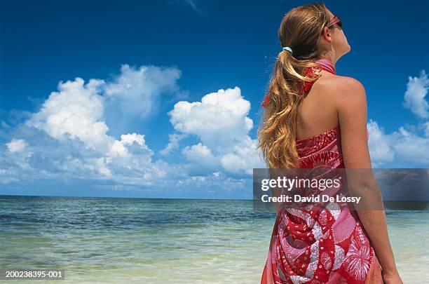 young woman wearing sarong, at beach - sarong imagens e fotografias de stock