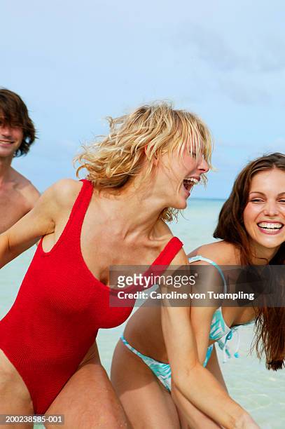 woman and friends playing in ocean, close-up - eendelig zwempak stockfoto's en -beelden