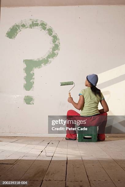 young woman painted big question mark on wall - think big stockfoto's en -beelden