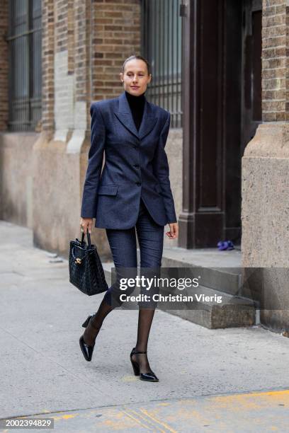 Guest wears navy tailored blazer, cropped pants, tights, bag outside Proenza Schouler on February 10, 2024 in New York City.