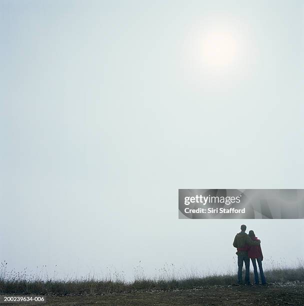 young couple on overlook, rear view - mid distance stock pictures, royalty-free photos & images