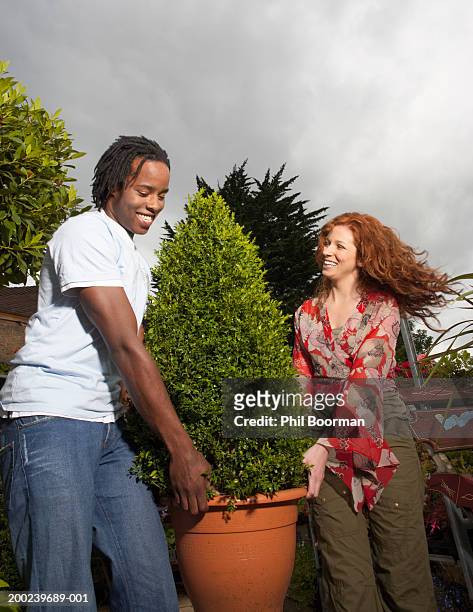 young couple carrying shrub, smiling - ginger bush stock pictures, royalty-free photos & images