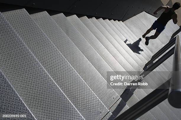 young man running down stairs outdoors, rear view - descending a staircase stock pictures, royalty-free photos & images