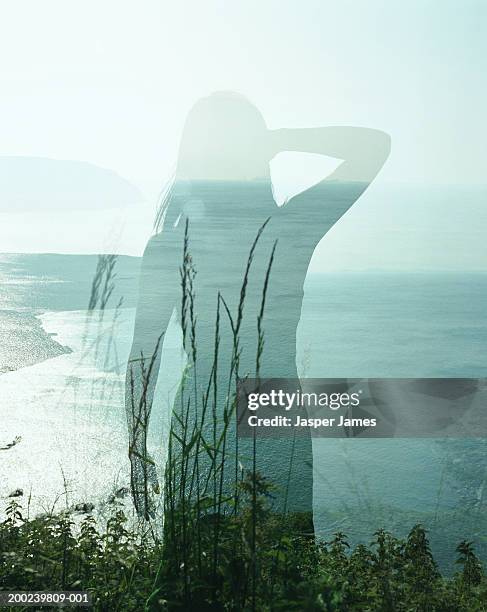 woman standing on cliff edge, rear view (double exposure) - double exposure woman fotografías e imágenes de stock