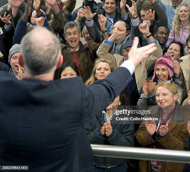 crowd of people cheering below businessman - 政治家 ストックフォトと画像