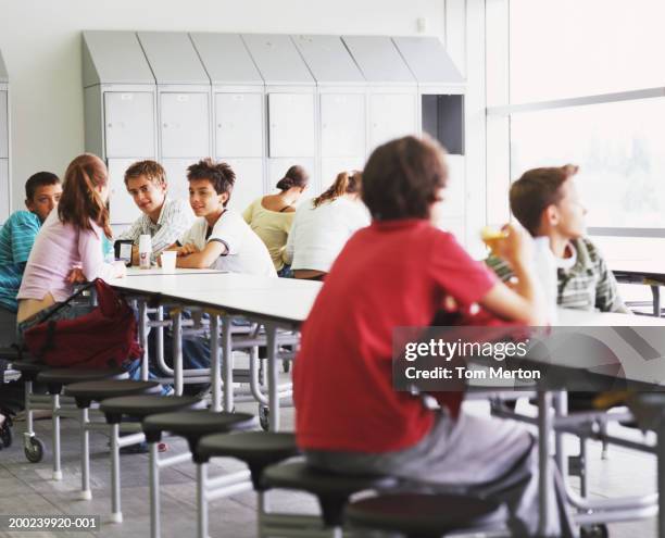 schoolchildren (12-16) having break in canteen - high school cafeteria stock pictures, royalty-free photos & images