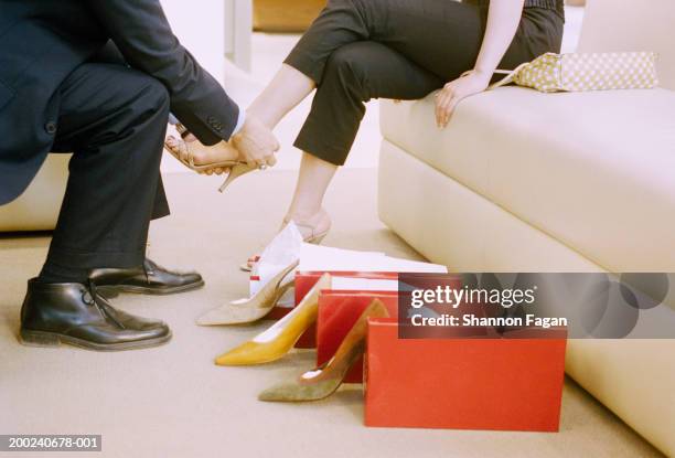 shoe salesman assisting woman in shop, low section, side view - eleganter schuh stock-fotos und bilder