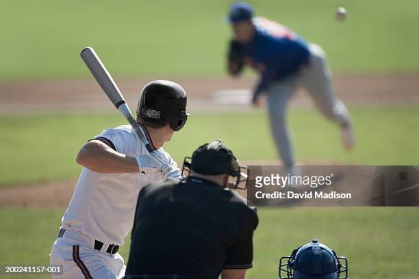 pitcher throwing pitch to batter, catcher and umpire in foreground - baseball sport stock pictures, royalty-free photos & images