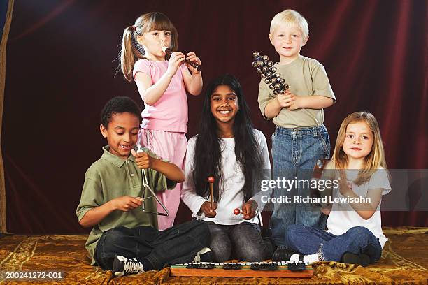 group of children (4-9) performing on stage with musical instruments, portrait - triangle percussion instrument stock pictures, royalty-free photos & images