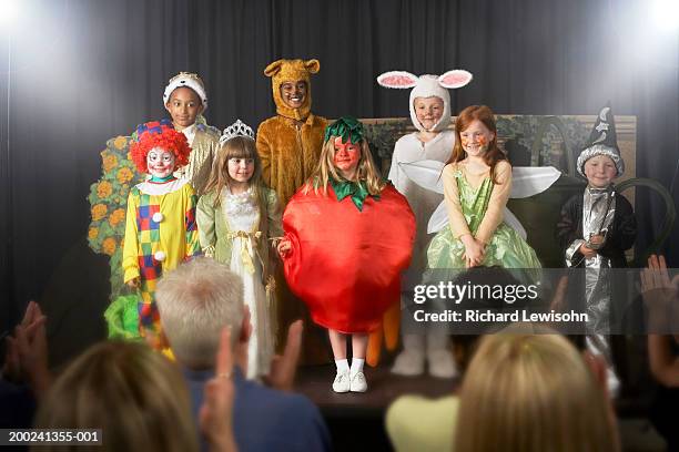 group of children (11-14) wearing costumes on stage, portrait - school play 個照片及圖片檔