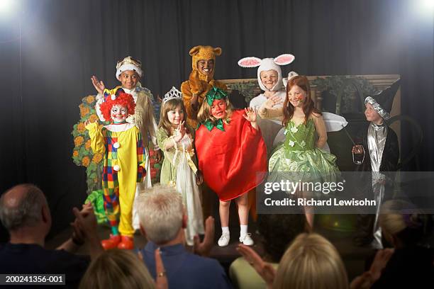 group of children (11-14) wearing costumes, waving on stage - skolpjäs bildbanksfoton och bilder