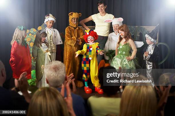 group of children (4-9) wearing costumes and teacher on stage - skolpjäs bildbanksfoton och bilder