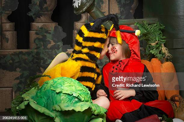 two girls (6-8) wearing bee and ladybird costumes, head to head - stage seven stock pictures, royalty-free photos & images