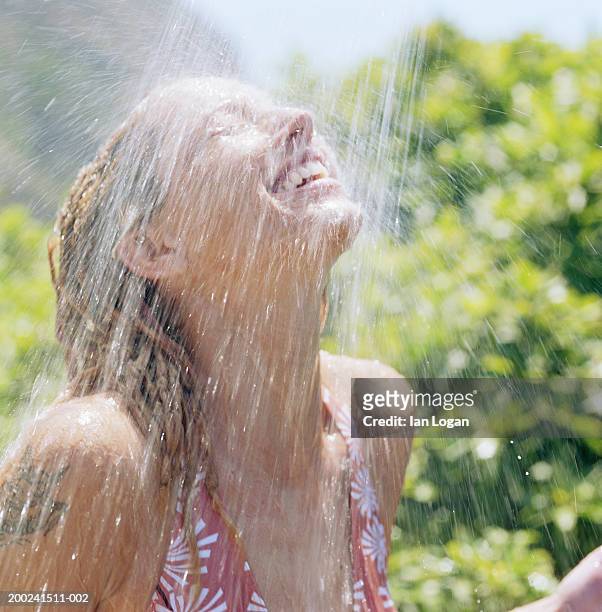 young woman in outdoor shower - woman in shower tattoo stock pictures, royalty-free photos & images