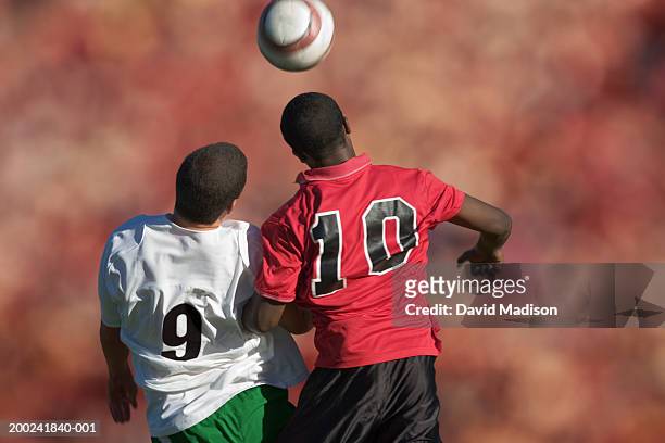 two male soccer players competing for ball (digital composite) - geköpft stock-fotos und bilder