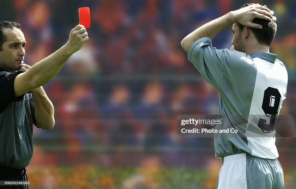 Referee showing football player red card