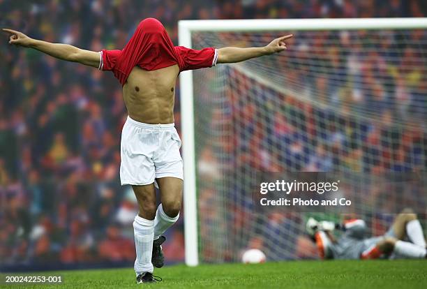 male football player rejoicing, football shirt over head - playing to win stockfoto's en -beelden