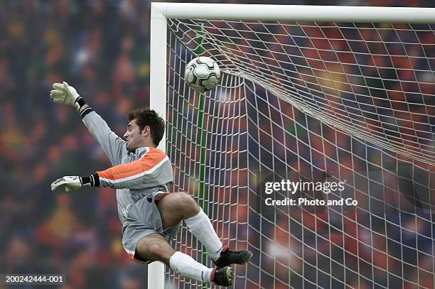 male football goalie trying to block goal in air - scoring a goal ストックフォトと画像