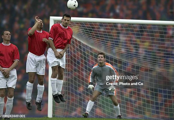 football players on field, one heading ball - heading the ball stockfoto's en -beelden