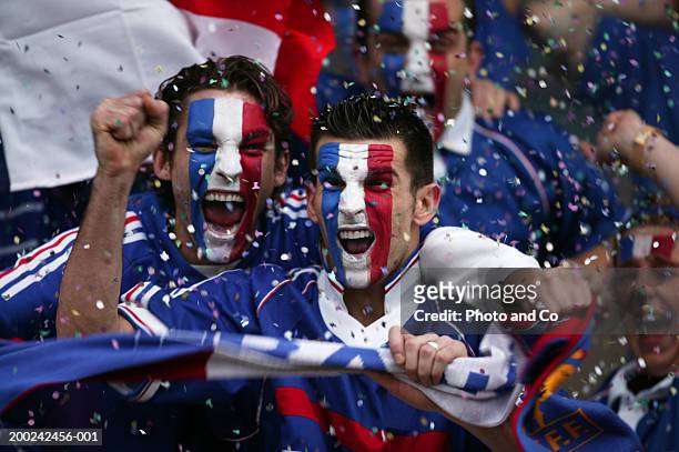 sports fans with french flags painted on faces, celebrating - fan stock-fotos und bilder