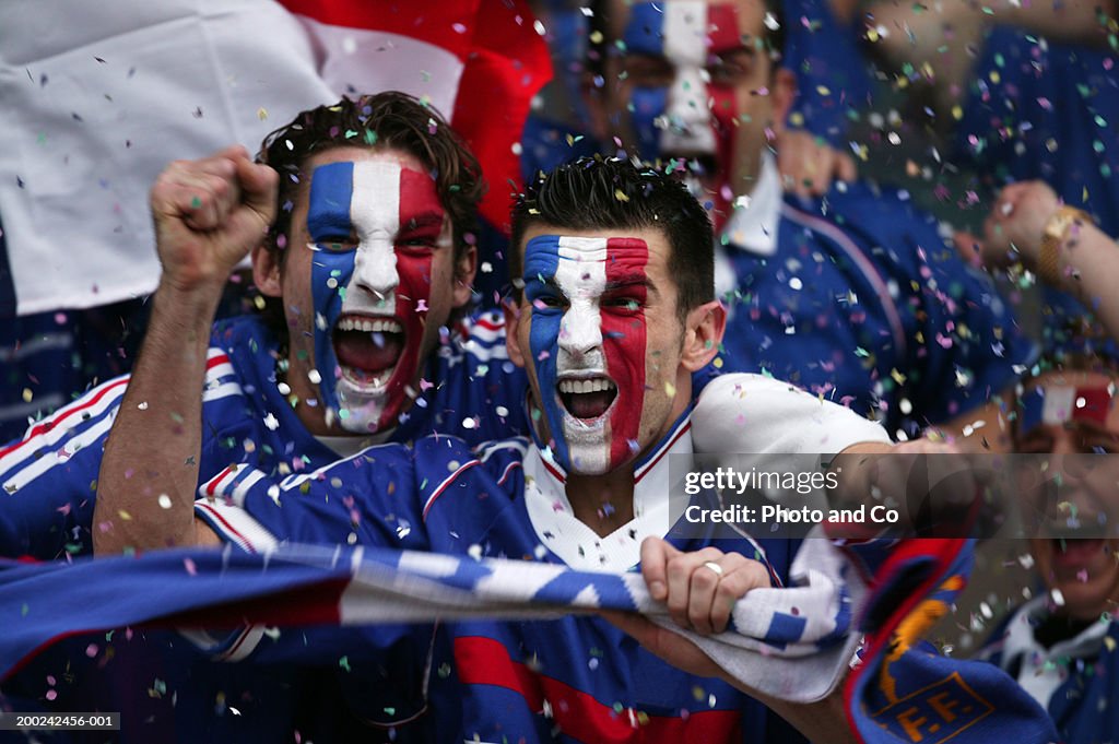 Sports fans with french flags painted on faces, celebrating