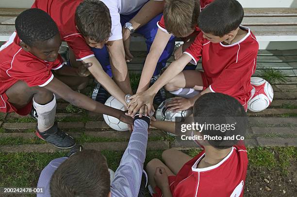 football team of boys (8-12) putting hands together in huddle - goalkeeper hand stock pictures, royalty-free photos & images