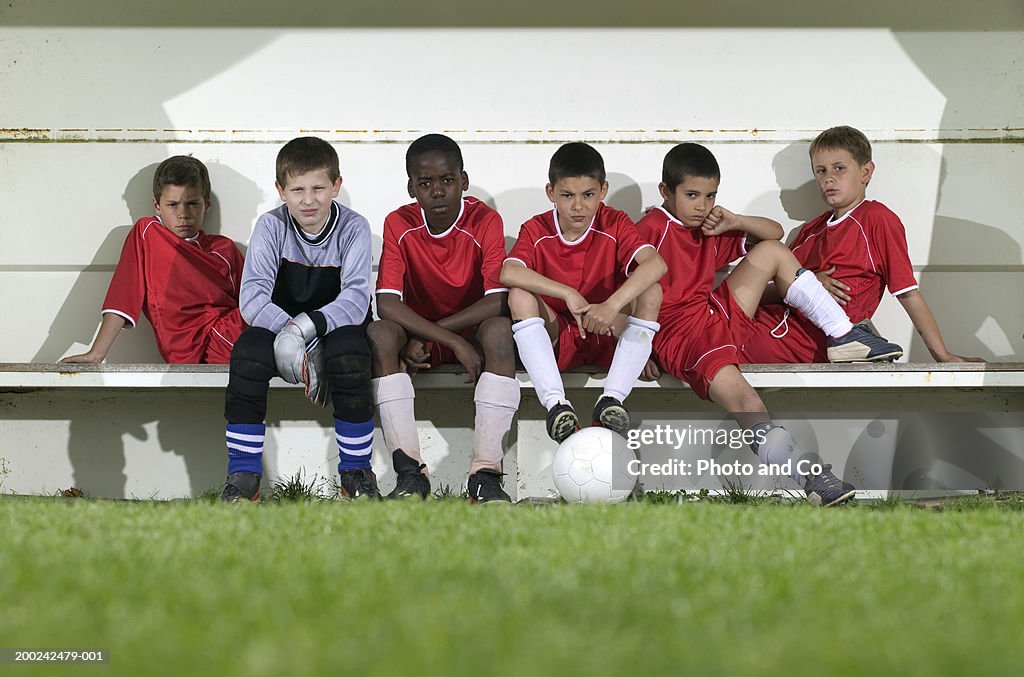 Football team of boys (8-12) sitting on bench, portrait