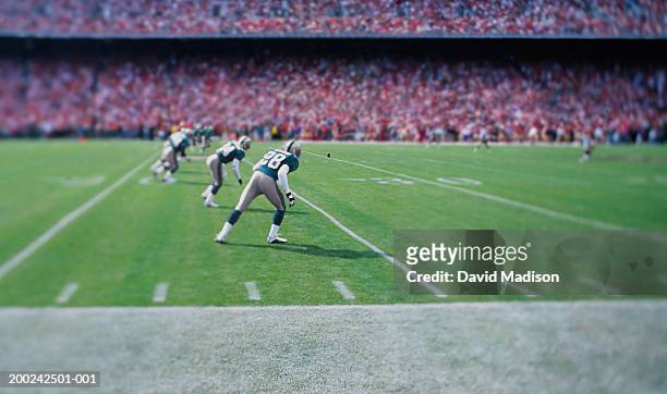 football players lined up for kick off in stadium (focus on player) - american football field stock pictures, royalty-free photos & images