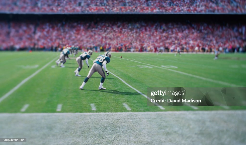 Football players lined up for kick off in stadium (focus on player)