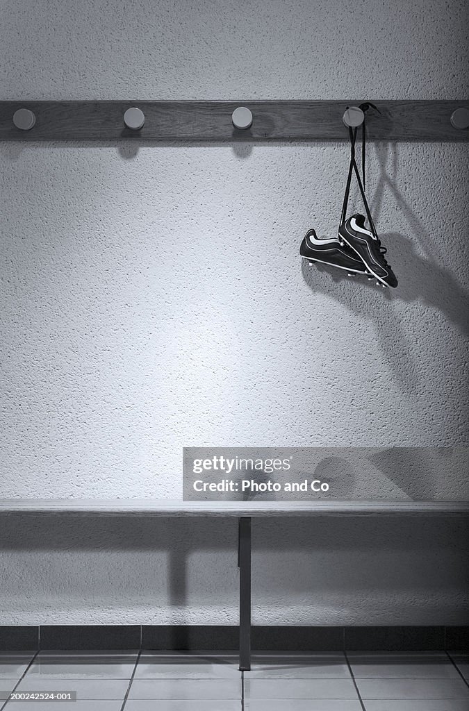 Football boots hanging in change room (B&W)
