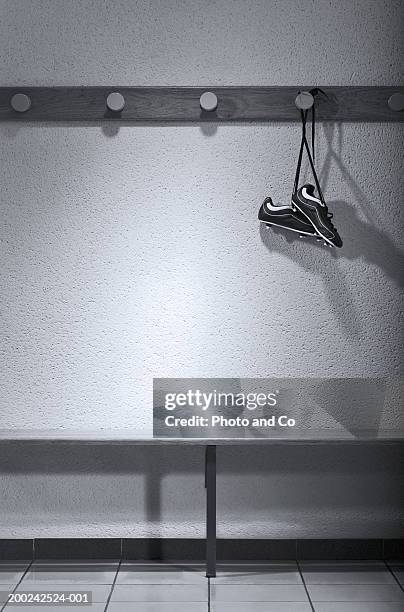 football boots hanging in change room (b&w) - locker room wall stock pictures, royalty-free photos & images