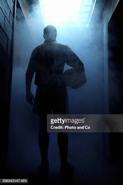 football player entering steam room, rear view - fußballspieler stock-fotos und bilder